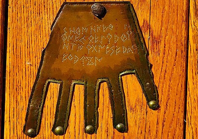 Una copia de la mano de Irulegi colocada en una puerta.