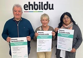 Ibon Altzelai, Belen Baztarrika y Amaia Galvez con el cartel del evento.
