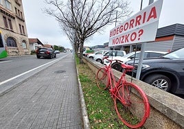 Cartel y bici roja en Mendelu, reclamando la creación de un bidegorri en la zona.