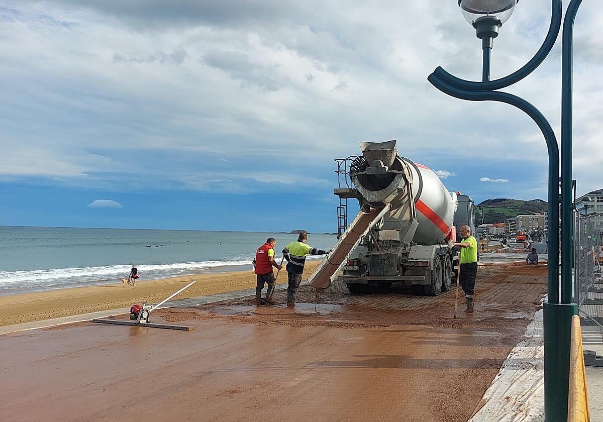 Operarios trabajando en la nueva pavimentación del malecón que será de hormigón impreso rojizo.