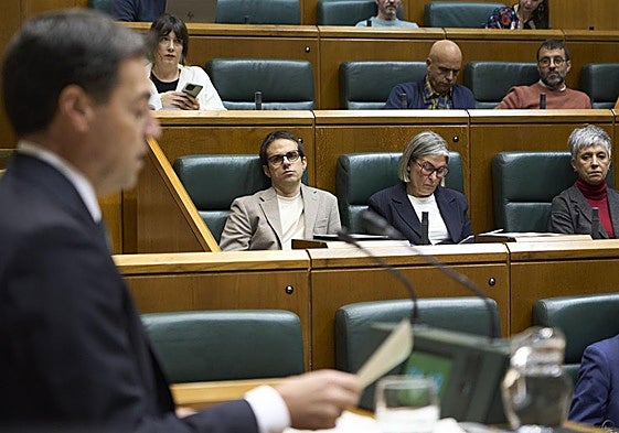 Imanol Pradales, durante su intervención este viernes en el Parlamento Vasco, con Pello Otxandiano escuchándole atento desde su escaño.