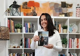 Arantza en su casa. Con su libro. Fotografiada por su hijo. A próposito se puso esos pantalones de colores, y con un 'animal print' divertido.