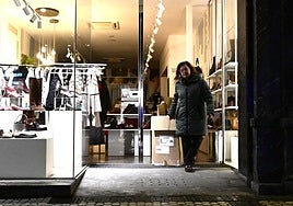 Estitxu, de calzados Tello de la calle Fuenterrabía, sacando el lunes por la noche los cartones a la entrada de su negocio.