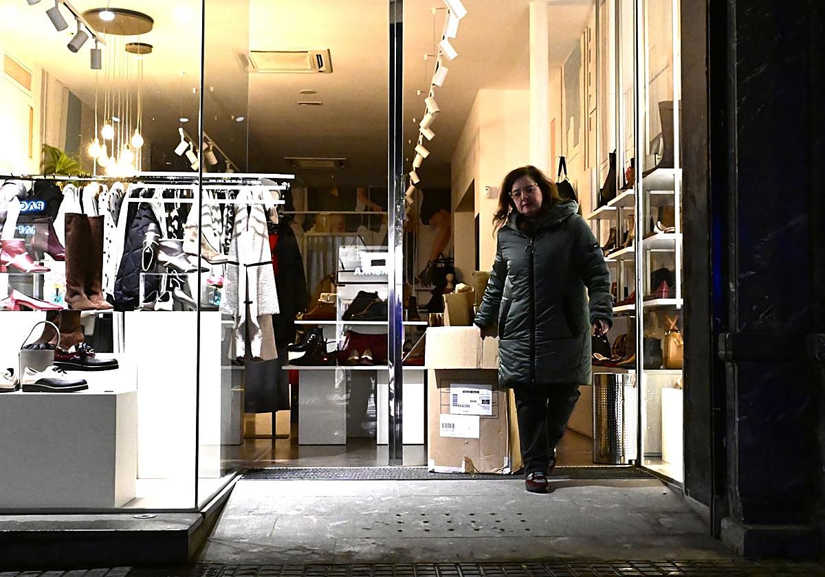Estitxu, de calzados Tello de la calle Fuenterrabía, sacando el lunes por la noche los cartones a la entrada de su negocio.