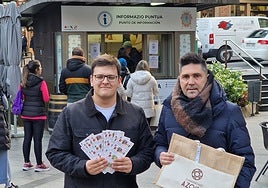 Iñaki Mendiluce y Mikel Serrano este viernes, al pie del quiosco donde de efectúa el reparto de bonos.