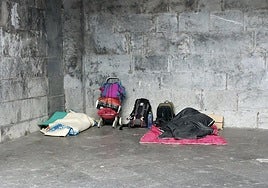 Dos personas sin hogar duermen por la noche en una calle de Tolosa.