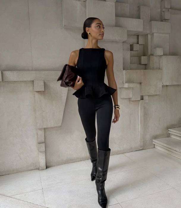El 'top peplum' en negro con 'leggins' y botas altas al tono.