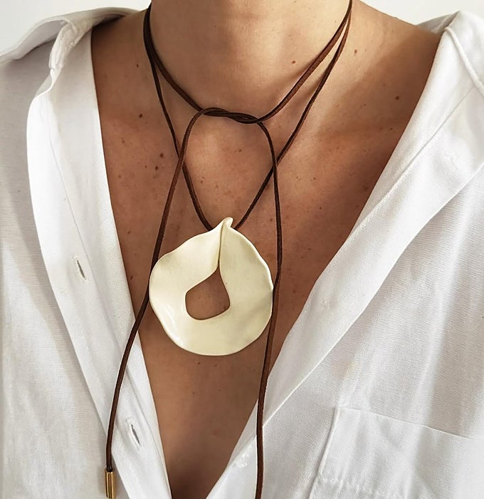 Collar de cordón marrón y pieza blanca.