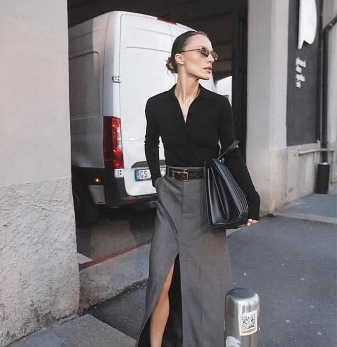 Camisa negra, falda lapiz gris con abertura y bolso negro.