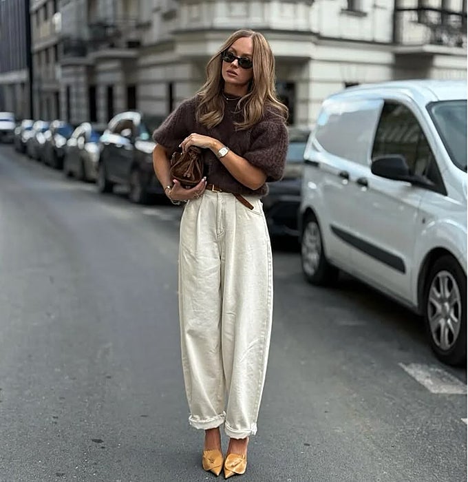 Jersey marrón y pantalones beige con tacones mostaza y bolso marrón.