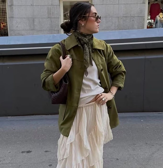 Chaqueta verde oliva y pañuelo al cuello sobre falda maxi de volantes escalonados en crudo.