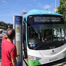 Un ciudadano consulta el recorrido del autobús en la parada junto a Anoeta
