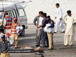 Personal de seguridad de Pakistán investigan en los alrededores de la fábrica de munición donde se ha producido el atentado./ AFP