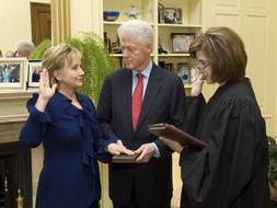 La nueva secretaria de Estado ha jurado ante la juez Kathleen Oberly. Su marido, el ex presidente Bill Clinton, sostenía la Biblia sobre la que ha pronunciado la fórmula de asunción del cargo. / Reuters