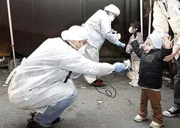 Un técnico mide los niveles de radiación a un niño en Fukushima. / Archivo
