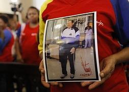 Una simpatizante de Chávez sostiene una fotografía suya. / Reuters