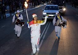 Un relevista con la antorcha olímpica de los próximos Juegos de invierno. / AFP