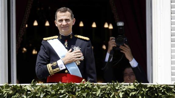 Felipe VI, emocionado y con la mano en el corazón en señal de agradecimiento, saluda a su pueblo desde el balcón del Palacio Real.  