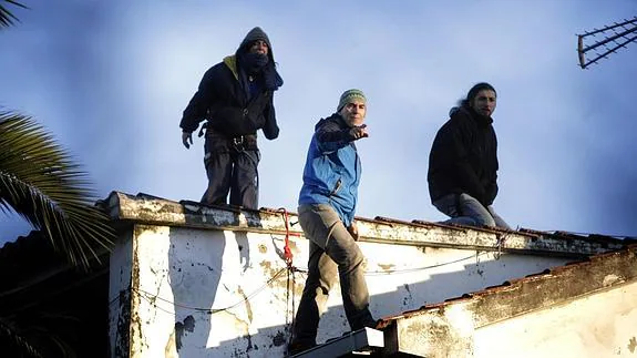 Roberto Rivas (c), el bombero que se negó a desahuciar a una anciana de A Coruña, y dos activistas de la plataforma Stop Desafiuzamentos encaramados en un tejado 