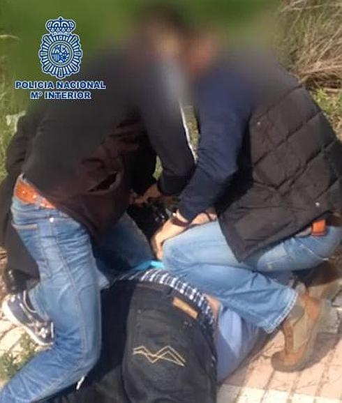 Dos agentes detienen al sospechoso. 