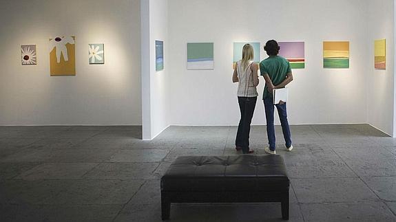 Dos jóvenes observan cuadros en un museo.