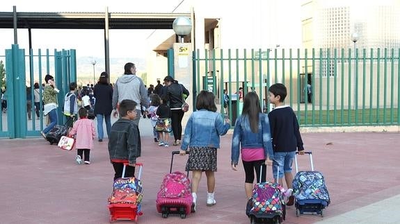 Niños entrando en un colegio.