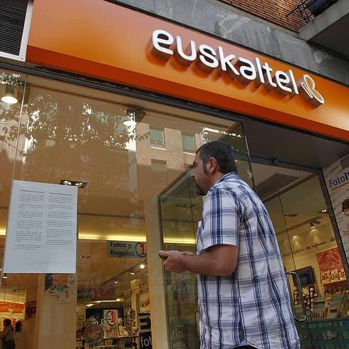 Una persona, ante el escaparate de una tienda de Euskaltel en Bilbao.