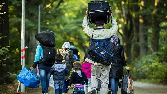Un grupo de refugiados abandona el centro de acogida de Heumensoord en Nimega, Holanda.
