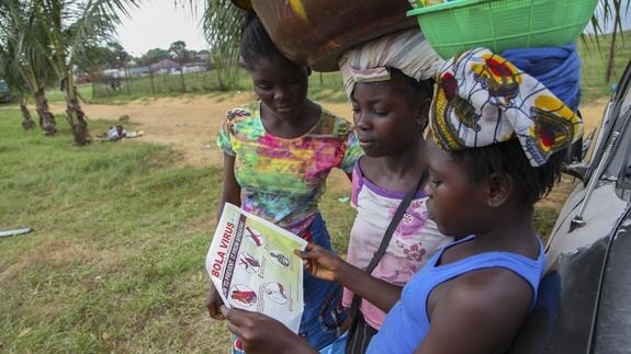Tres mujeres consultan un folleto sobre el ébola en Liberia. 
