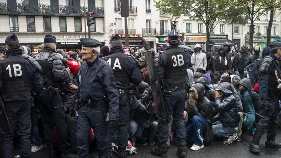 Policía galos desalojan un campamento de inmigrantes en París. 