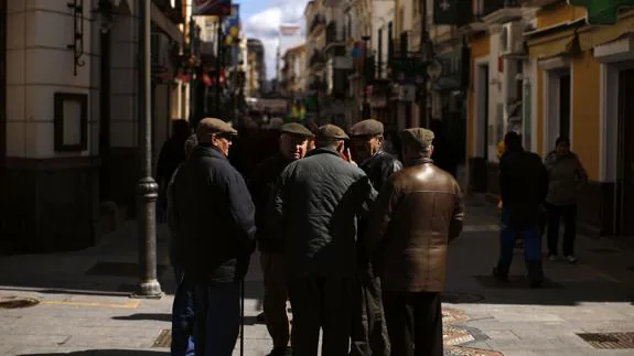 Pensionistas charlan en la calle peatonal de La Bola, en Ronda (Málaga).