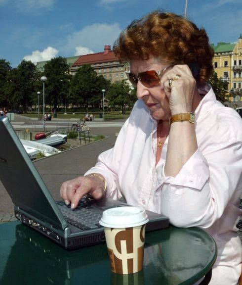 Una mujer trabaja sentada en una terraza.