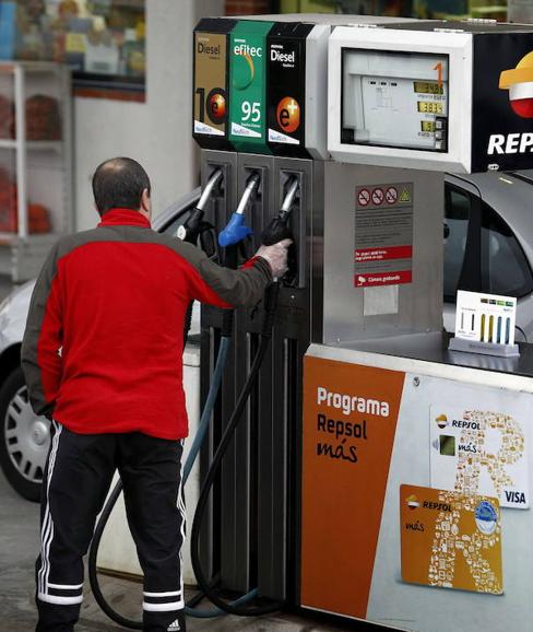 Un hombre se dispone a respostar en una gasolinera.