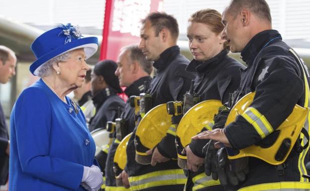 Isabel II conversa con unos bomberos.