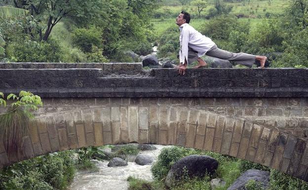 Un hombre practicando yoga al aire libre.