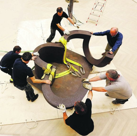 Ignacio Chillida y varios operarios colocan una de las obras que se podrán ver en la exposición de la Sala Kubo.