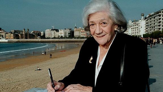 Ana María Matute firma un libro ante la playa de La Concha.