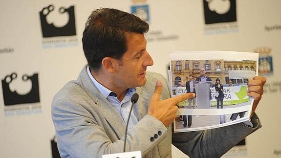 Ramón Gómez muestra una foto de Izagirre durante la rueda de prensa