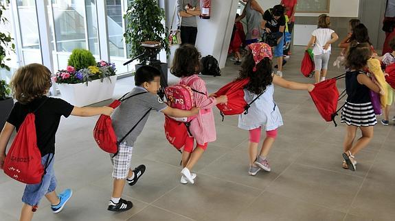 Varios niños acceden a las aulas en el primer día del curso escolar 2014 - 2015, en la nueva escuela Legarda de Mungia. 