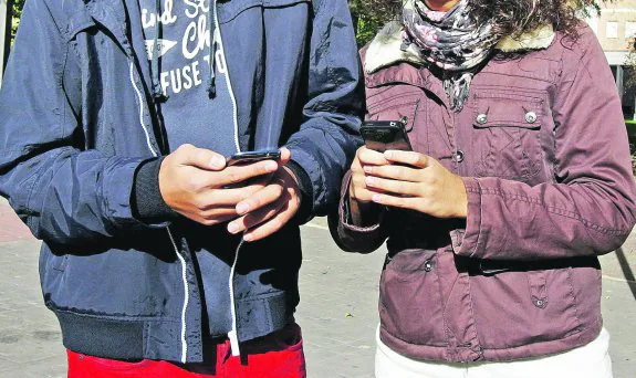 Una pareja utiliza sus teléfonos móviles.