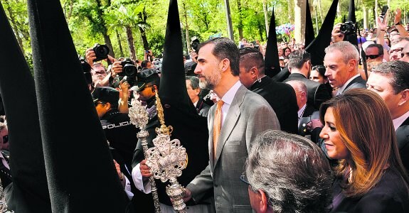 Felipe de Borbón y Susana Díaz, entre los nazarenos de la hermandad de Santa Genoveva en el Parque de María Luisa, en Sevilla. 