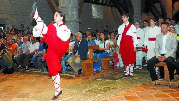 Oihane Vicente, la primera mujer que baila la ezpata-dantza en Antigua, intrepreta el baile ante la atenta mirada del alcalde y de los fieles. 