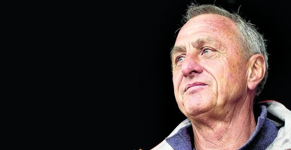 Cruyff, que tiene ahora 68 años, en una foto de 2013. Abajo, apurando un cigarrillo y disfrutando de un chupachups. 