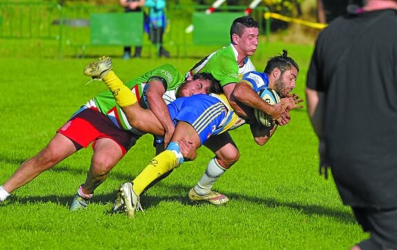 Dos jugadores del Hernani placan a uno del Pozuelo en un momento del encuentro disputado ayer en Landare.