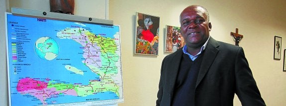 El sacerdote Theodule Dumond posa junto al mapa de Haití en las oficinas de la delegación de Misiones de la diócesis en San Sebastián.
