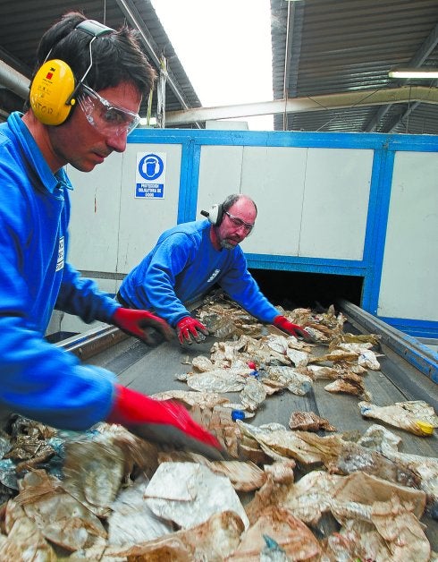 Dos operarios de Eko-REC seleccionan las botellas transparentes.