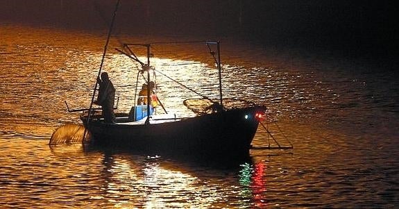 En mitad de la noche, las luces de los barcos iluminan la desembocadura del Oria, la cuenca donde más permisos de pesca de angula hay en Euskadi.