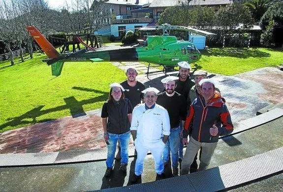 Volando. Ignacio Muguruza, con su equipo, ante el helicóptero que aterrizó en su jardín. 