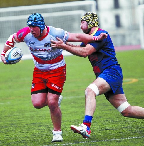 Un jugador del Ampo trata de zafarse de un rival ayer en Altamira. 