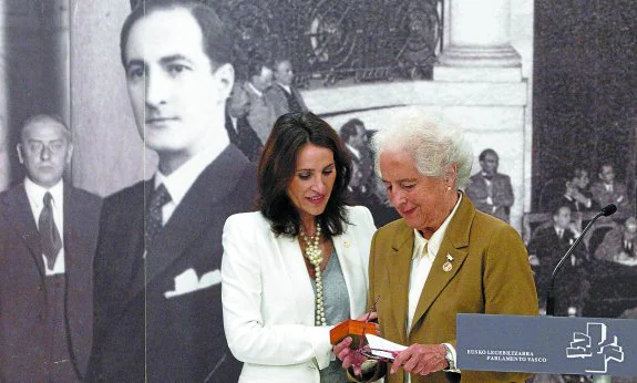 La hija de José Antonio Agirre, Aintzane Agirre, recibe de manos de la presidenta de la Cámara vasca, Bakartxo Tejeria, la insignia de parlamentario en homenaje a su padre. 